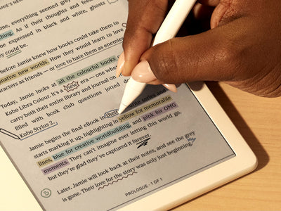 Una mano utilizza il Kobo Stylus 2 per scrivere direttamente in un eBook su un eReader Kobo Libra Colour su una superficie piana. Sulla pagina vediamo annotazioni e evidenziazioni colorate.